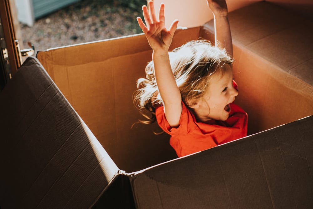 A happy child playing in a box near modSTORAGE in Aspen, Colorado