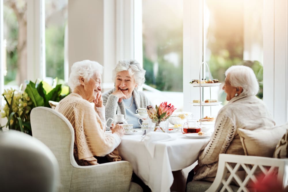 3 senior residents socializing around a table at The Sycamore of River Falls in River Falls, Wisconsin