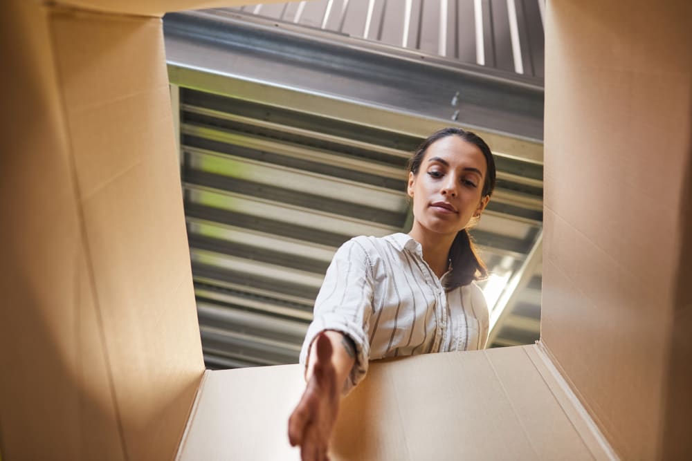 a customer reaching into a box at Trojan Storage of Shoreline in Shoreline, Washington