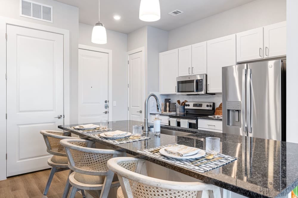 Apartment kitchen with white cabinets and stainless steel appliances at The Avery in Austin, Texas