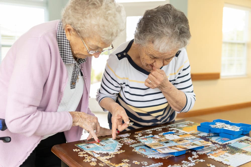 Residents solving a puzzle together at The Wellington Senior Living in Liberty, Missouri