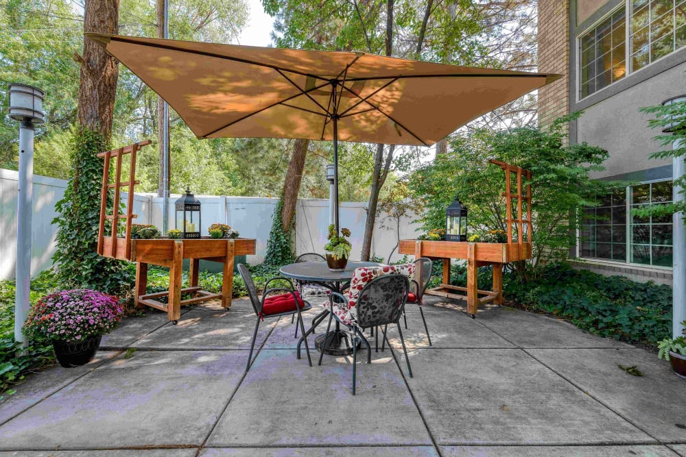 Outdoor seating area with umbrella at Pacifica Senior Living Millcreek in Salt Lake City, Utah