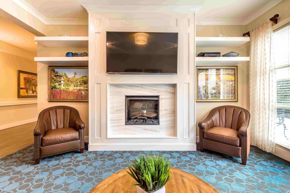 Lounge area with fireplace and TV at Pacifica Senior Living Mission Villa in Daly City, California