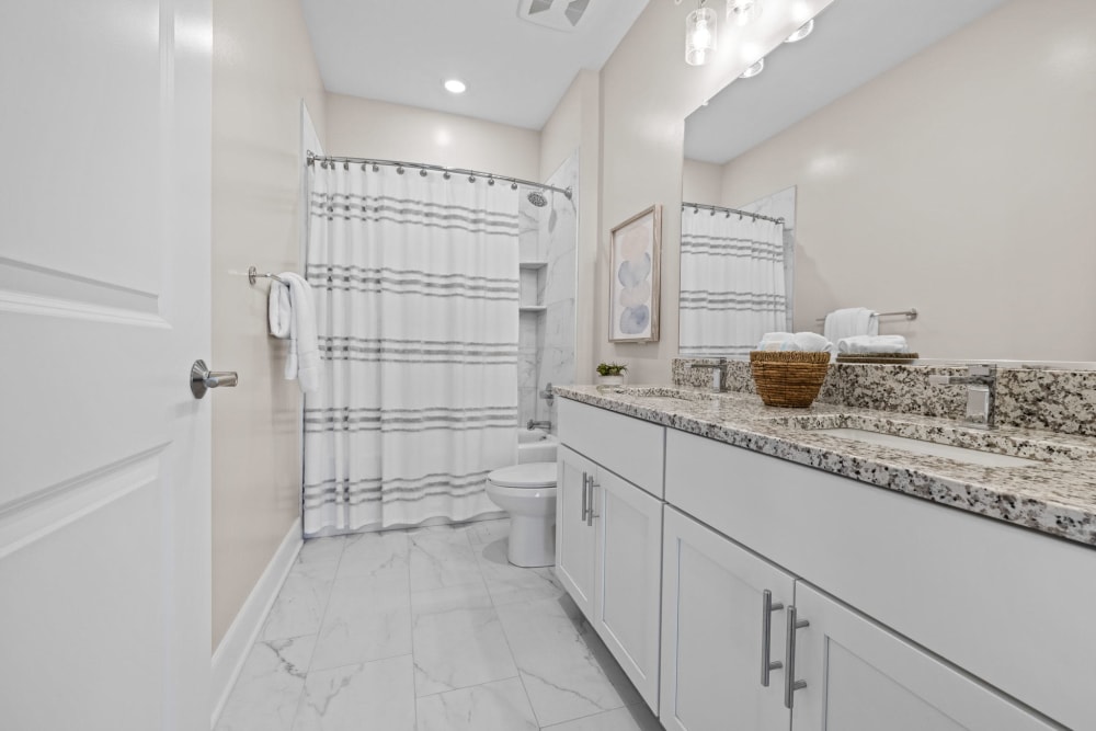 Spacious bathroom with granite countertops at Village Square Apartments in Norfolk, Virginia