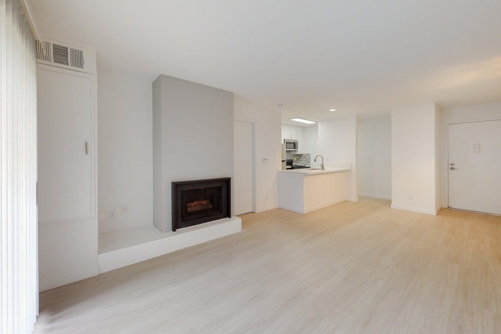 Living room with wood flooring and a fireplace at Club Marina Apartments in Los Angeles, California