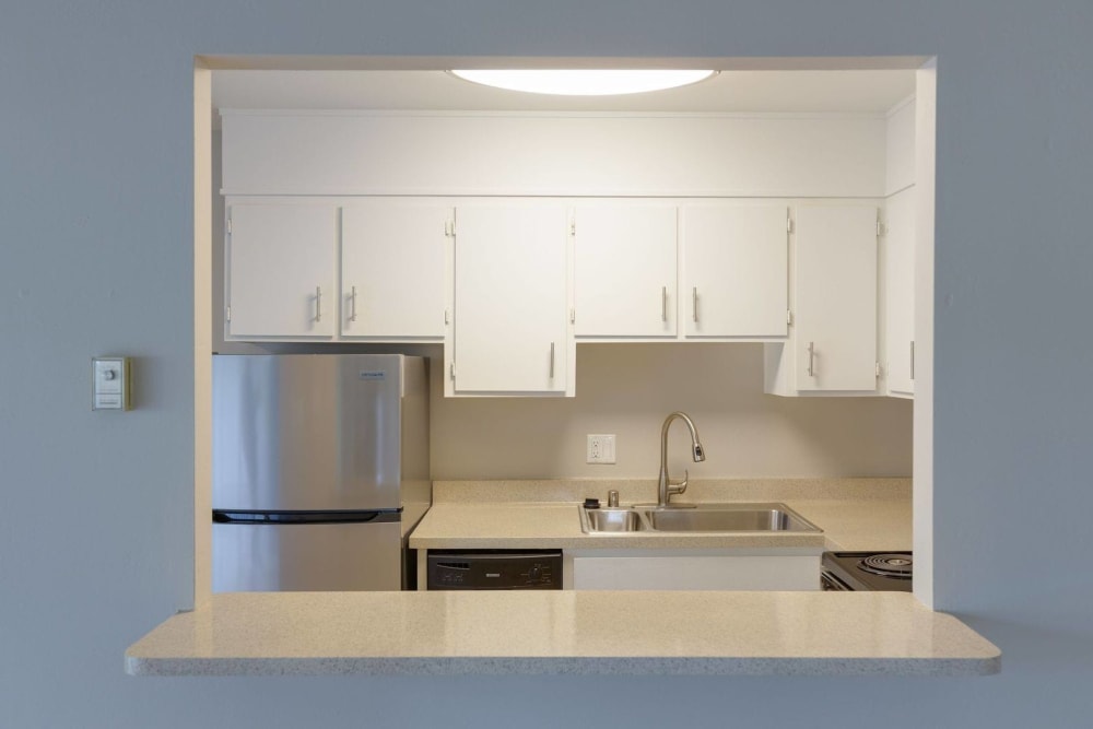 Window into the kitchen with counter seating at Catalina Crest Apartment Homes in Livermore, California