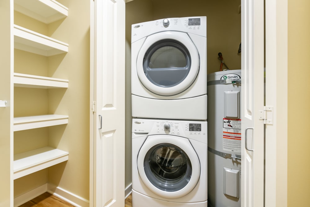 Stacked washer and dryer and the pantry storage shelves in an apartment at The Meridian in Salem, Oregon
