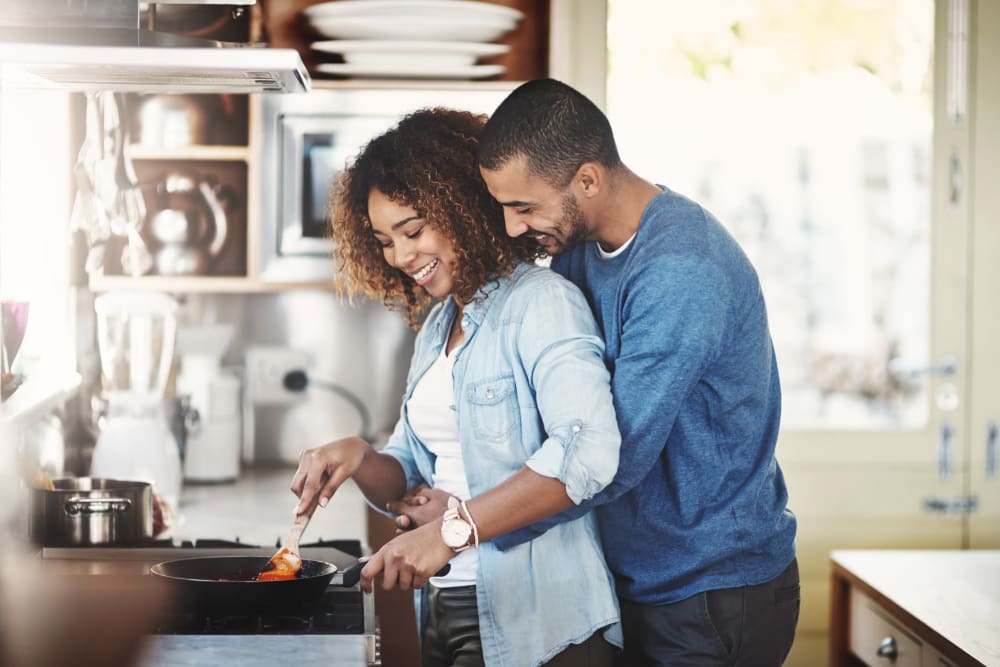 A couple cooking a meal in modern kitchen at Miro Brickell in Miami, Florida