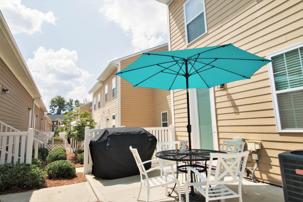 Back patio area with a bbq and table at Charleston Row Townhomes in Pineville, North Carolina