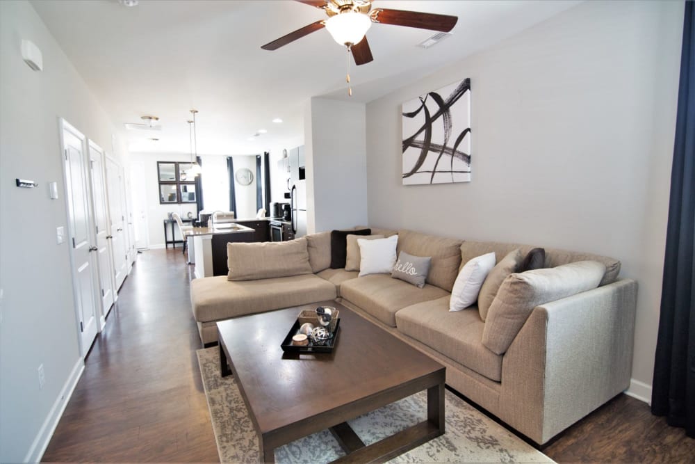 Living room with a quality ceiling fan at Charleston Row Townhomes in Pineville, North Carolina