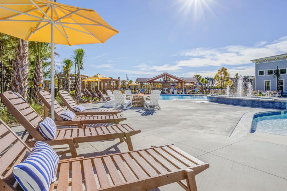 Beach-style chairs, cushions and umbrellas surround the pool at The Hudson at Cane Bay in Summerville, South Carolina