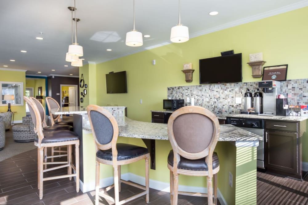 Common area bar seating with coffee machine and a wall-mounted television at 29 North in Hickory, North Carolina