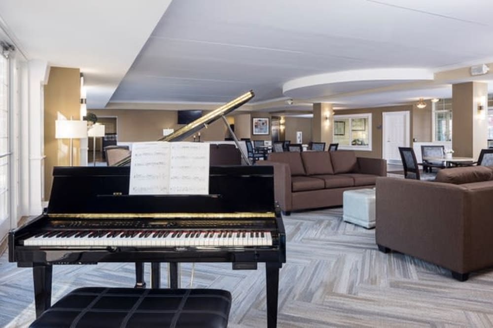 Piano and plush seating in lobby lounge at Hanover Place in Tinley Park, Illinois.