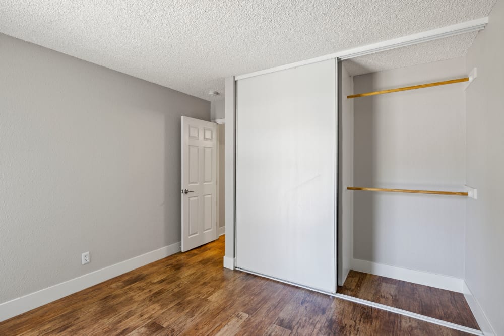 Spacious primary bedroom with large closets and hardwood style flooring at Bidwell Park Fremont in Fremont, California