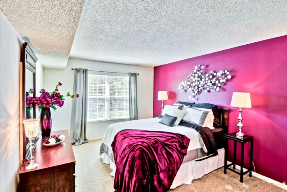 cozy bedroom with magenta wall at Willow Lake Apartments in Virginia Beach, Virginia
