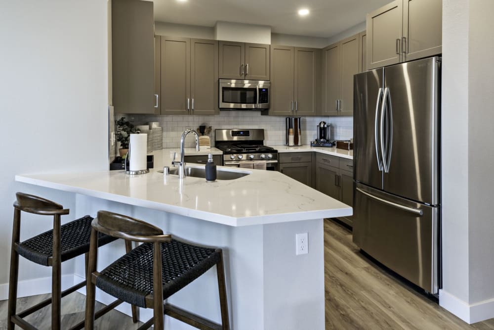 Apartment kitchen with hardwood floors and stainless steel appliances at Parador Townhomes in Clovis, California