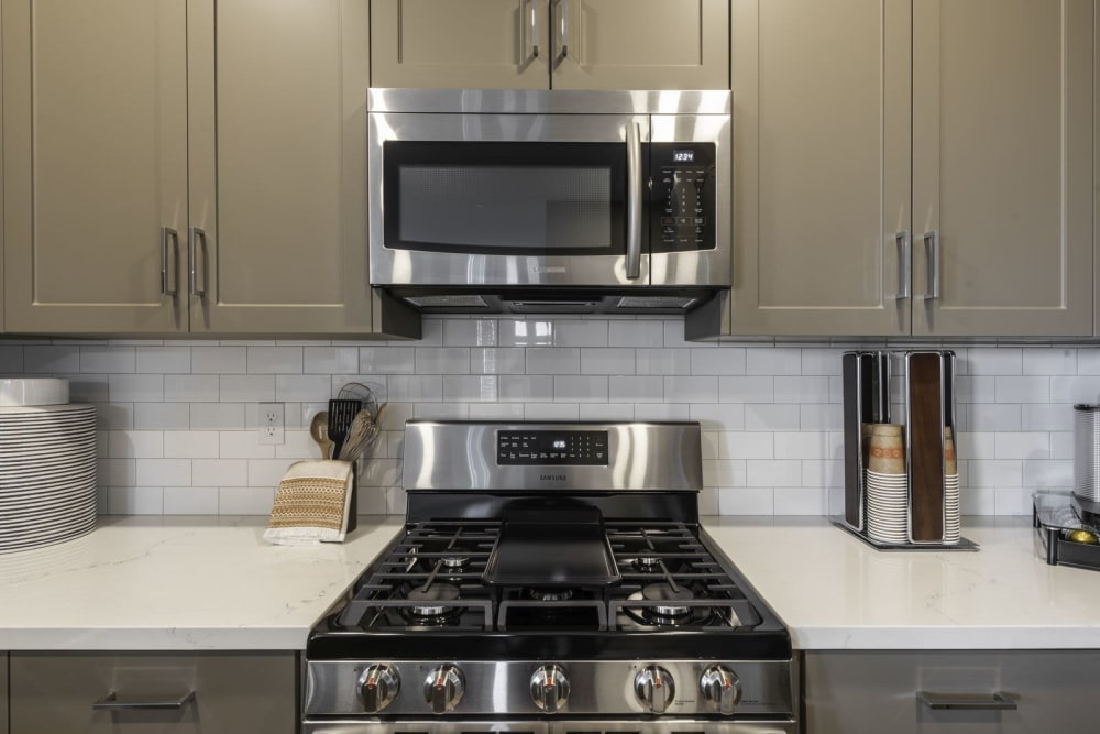 Stove and overhead microwave and white countertops at Parador Townhomes in Clovis, California