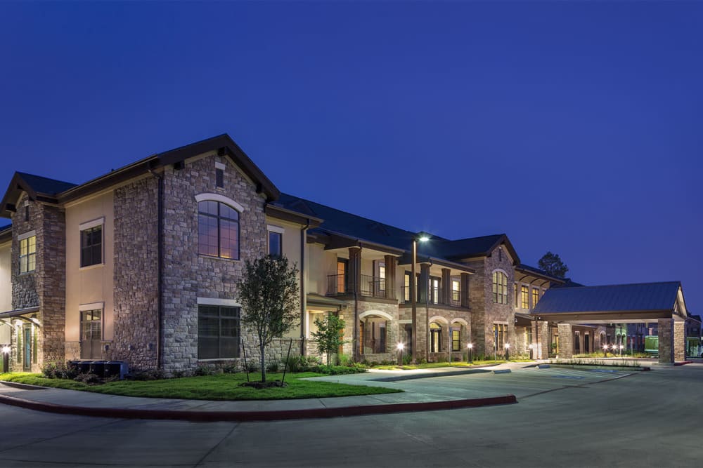 The building exterior at night with the lights on at Spring Creek Village in Spring, Texas