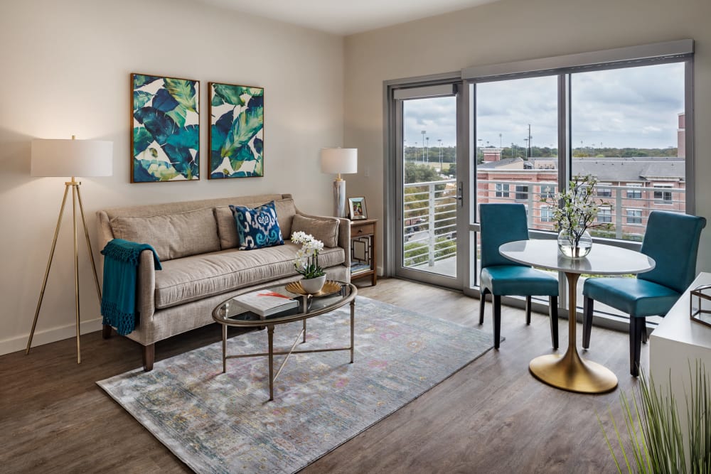 An apartment living room and doors to the balcony at The Village at The Triangle in Austin, Texas