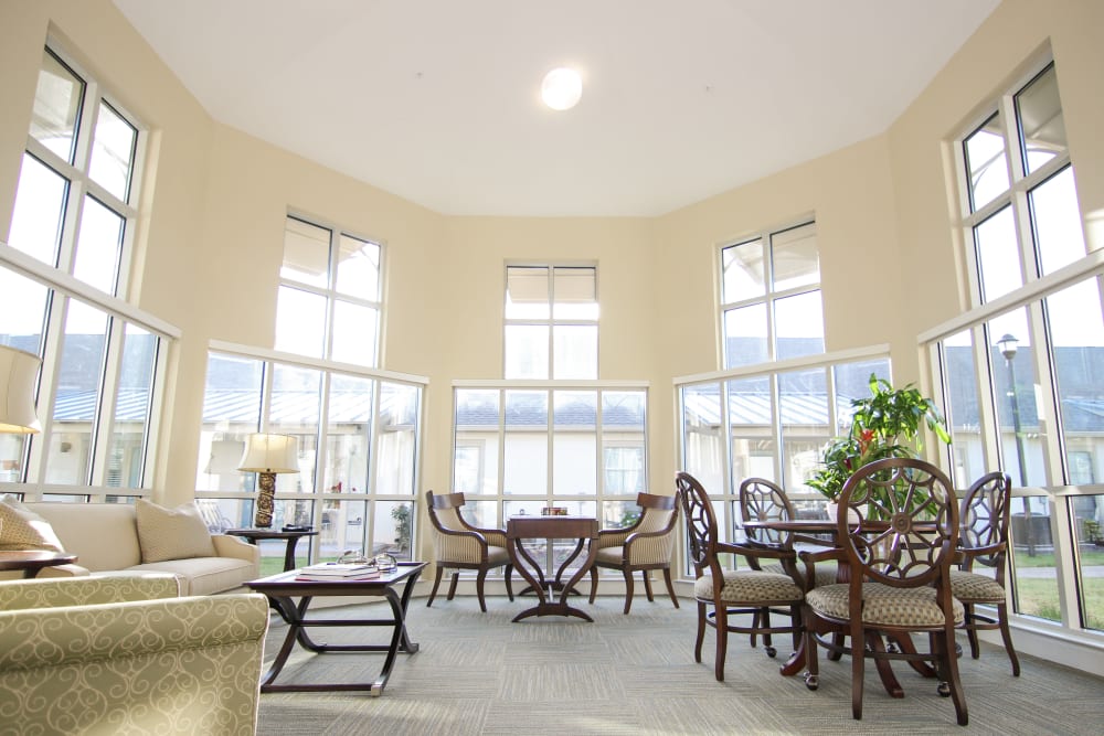 A community lounge surrounded by windows at Village on the Park Onion Creek in Austin, Texas