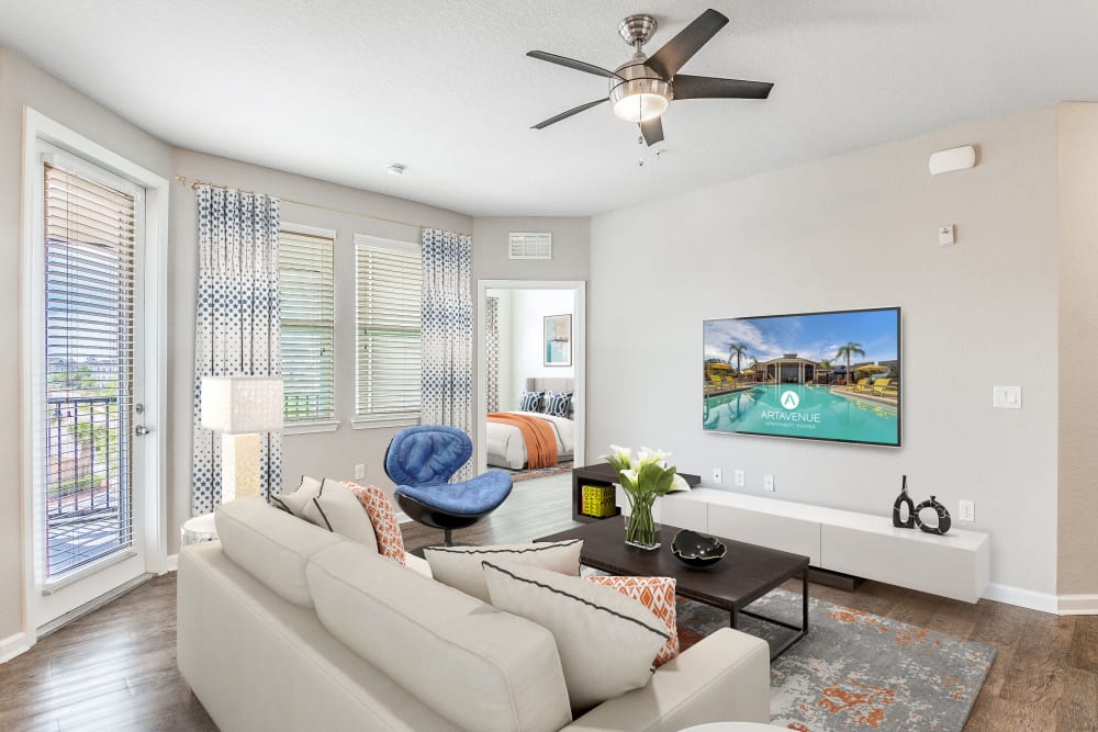 Spacious apartment living room with large couch and flat-screen tv at Art Avenue Apartment Homes in Orlando, Florida