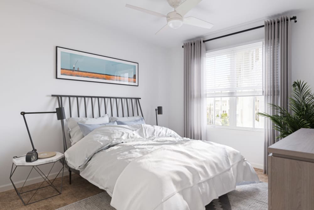 Bedroom with a ceiling fan and plush carpeting in a model apartment at Primrose at Santa Rosa Beach in Santa Rosa Beach, Florida