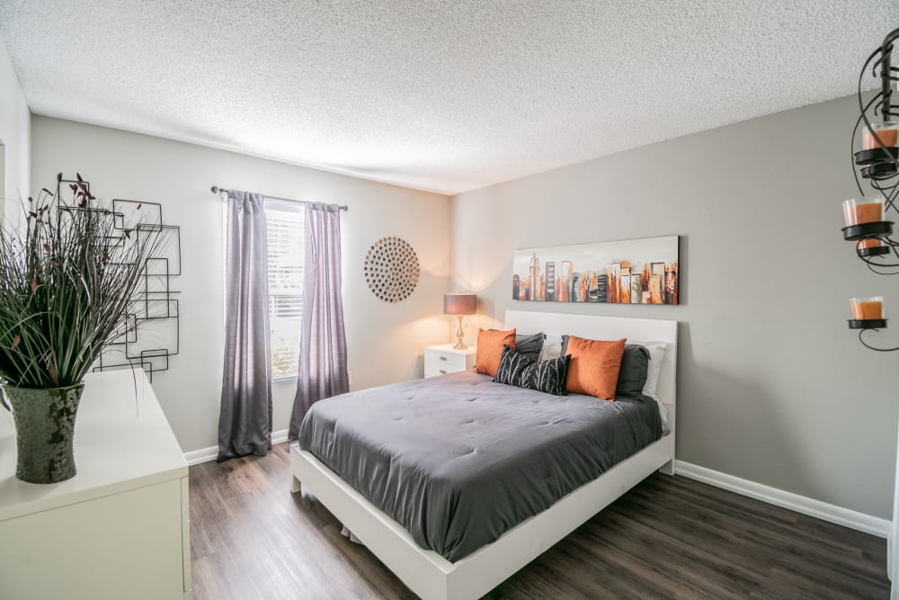 Spacious apartment bedroom with a window and wood-style plank flooring at Coopers Pond in Tampa, Florida
