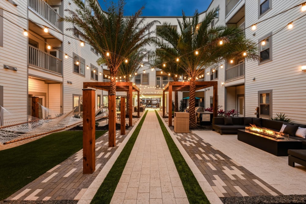 Outdoor courtyard with palm trees and string lights at Soba Apartments in Jacksonville, Florida