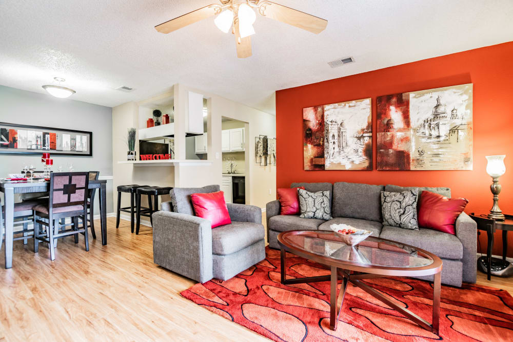 Model living room with red accents at Waterstone At Carrollwood in Tampa, Florida