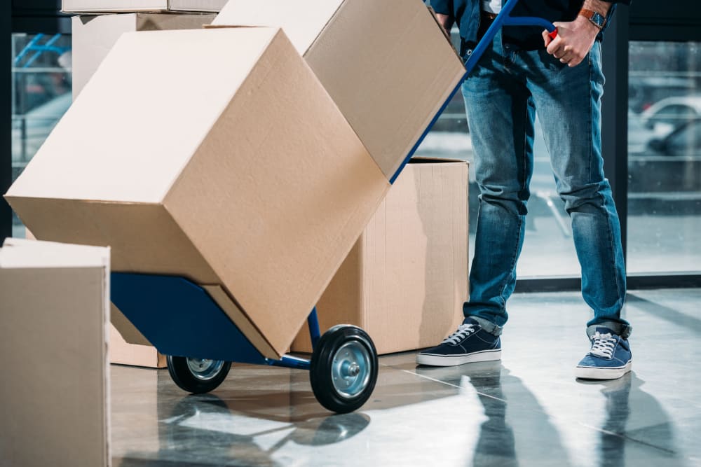 A customer moving boxes with a dolly at modSTORAGE Rifle in Rifle, Colorado