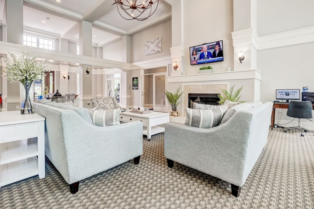 Spacious lobby with seating, a t.v. and a fireplace at Falls Creek Apartments & Townhomes in Raleigh, North Carolina