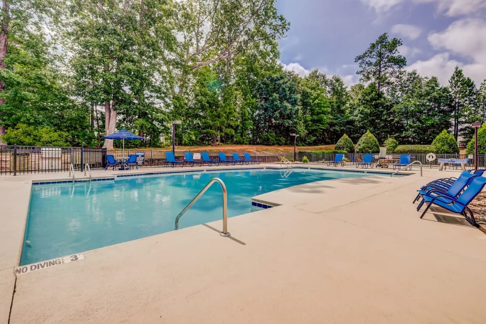 Wooded area next to a luxurious pool Heather Park Apartment Homes in Garner, North Carolina