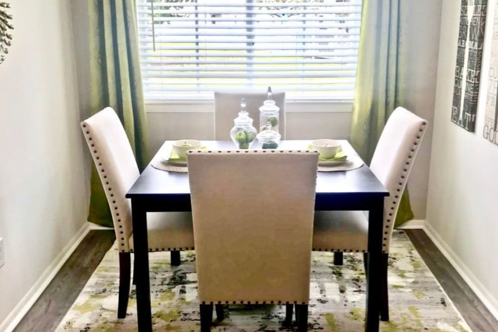 the dining room table lit up by a nearby window at Greenbrier Woods Apartments in Chesapeake, Virginia
