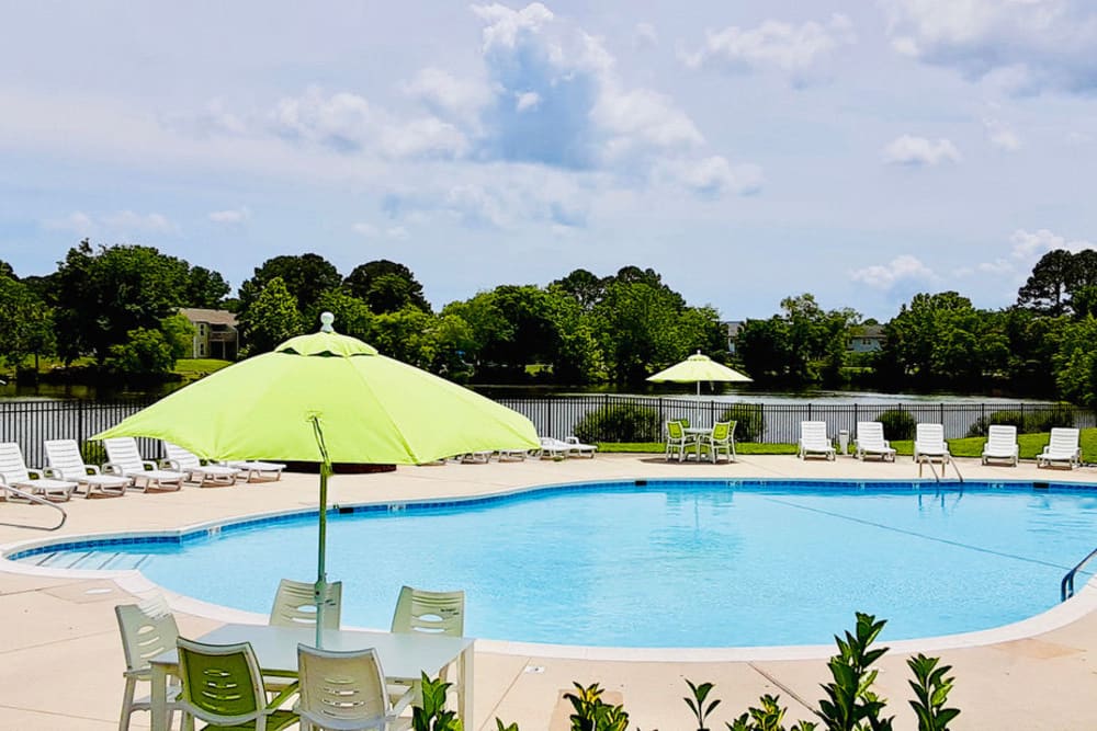community pool with umbrella at Windsor Lake Apartments in Virginia Beach, Virginia