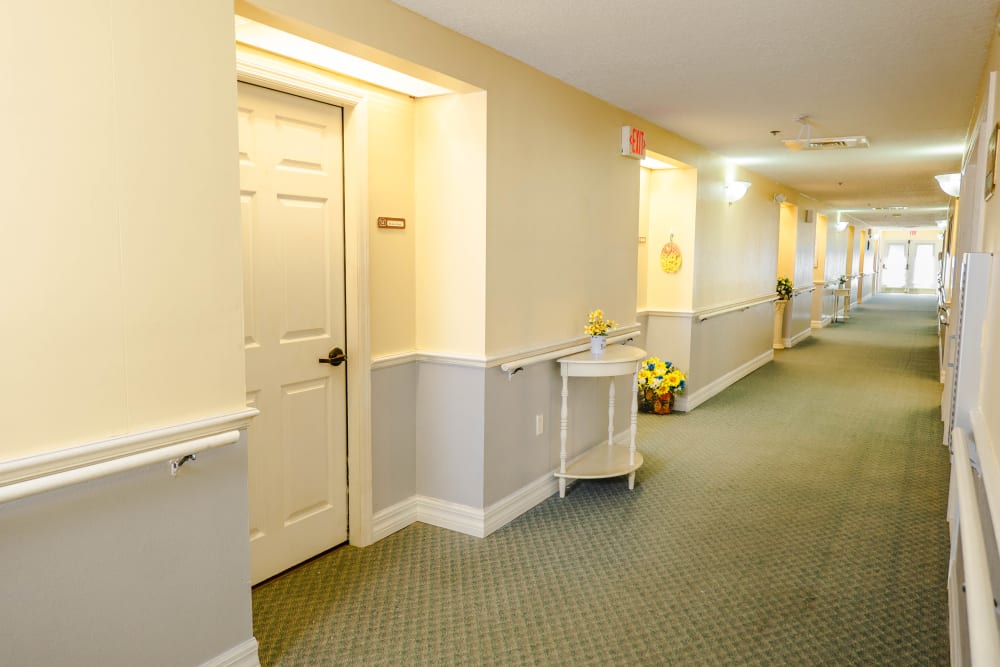 Wide bright hallways with individual apartment entries at The Club at Lake Wales in Lake Wales, Florida