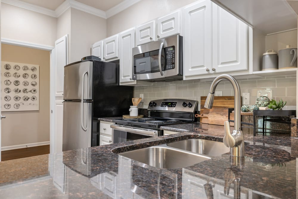 Bright kitchen with granite counters and stainless steel appliances at Marquis at Carmel Commons in Charlotte, North Carolina 