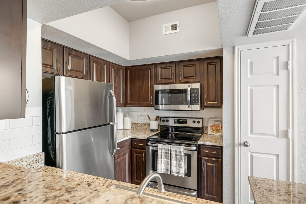 Updated kitchen with granite countertops at Marquis at Stonegate in Fort Worth, Texas