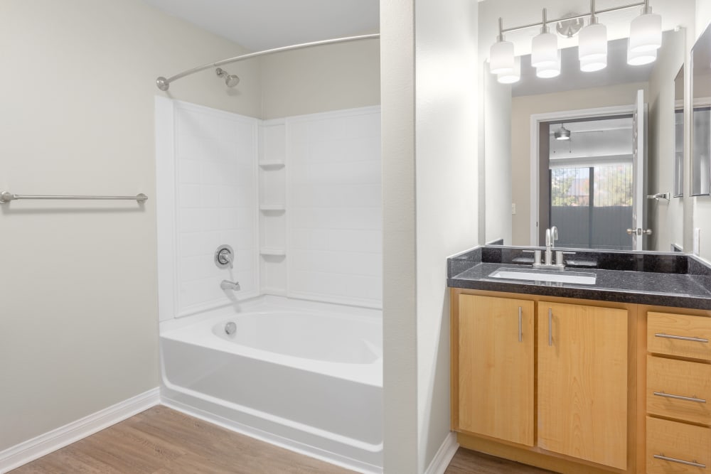 Bathroom with large vanity mirror and shower bathtub at Sierra Oaks Apartments in Turlock, California