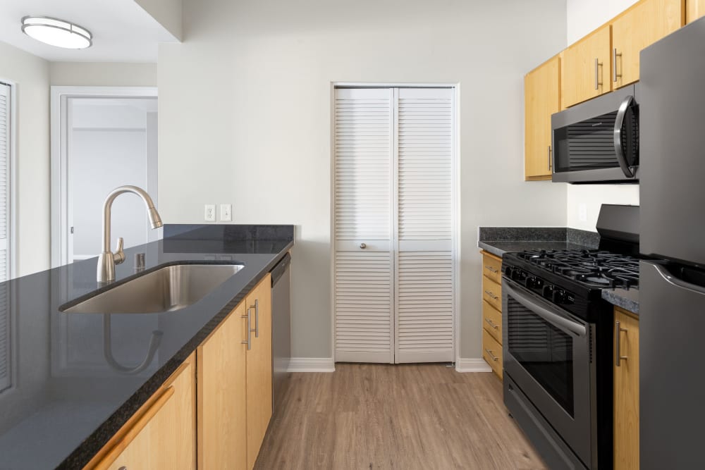 Kitchen with black countertops and appliances at Sierra Oaks Apartments in Turlock, California