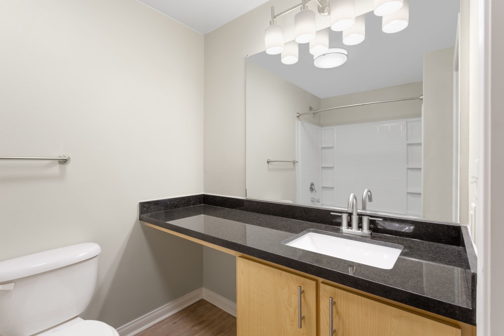 Bathroom with black countertops at Sierra Oaks Apartments in Turlock, California