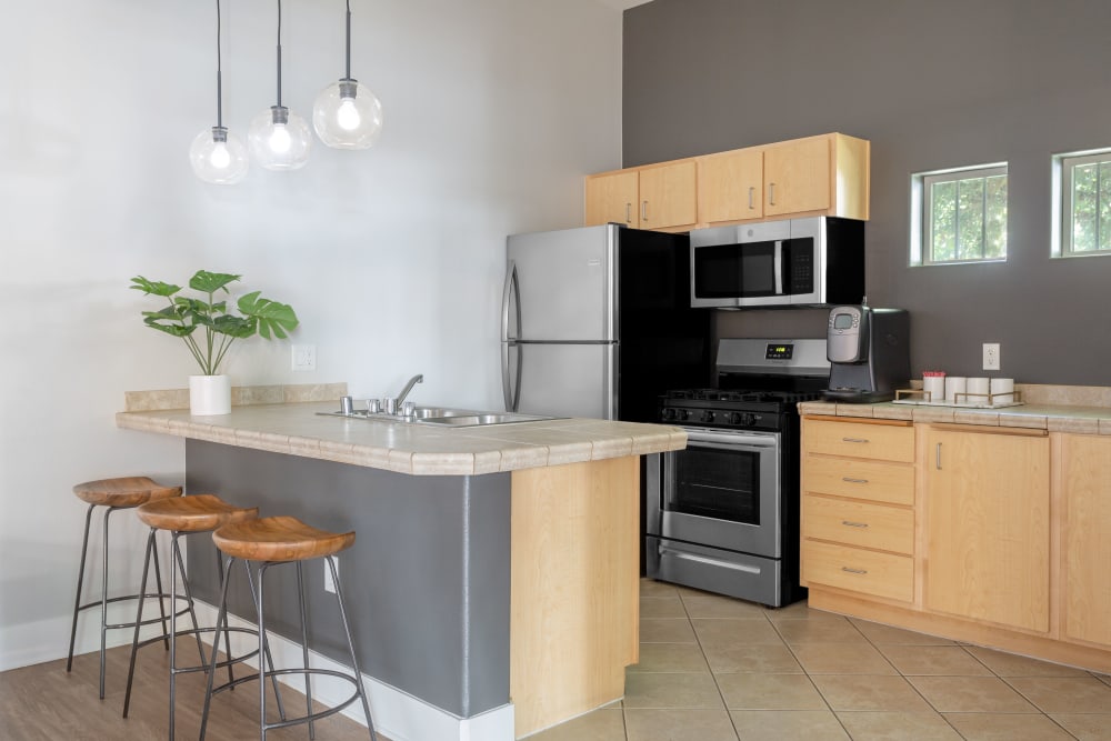 Kitchen with breakfast bar seating and modern appliances at Sierra Oaks Apartments in Turlock, California