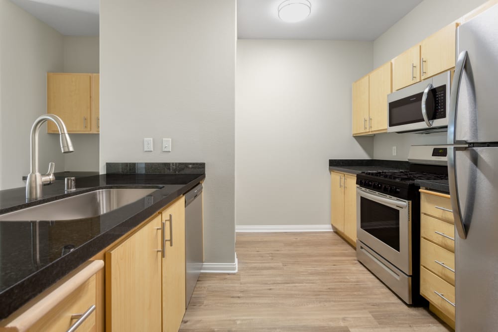 An apartment at Sierra Oaks Apartments in Turlock, California features a kitchen with ample storage and stainless steel appliances.