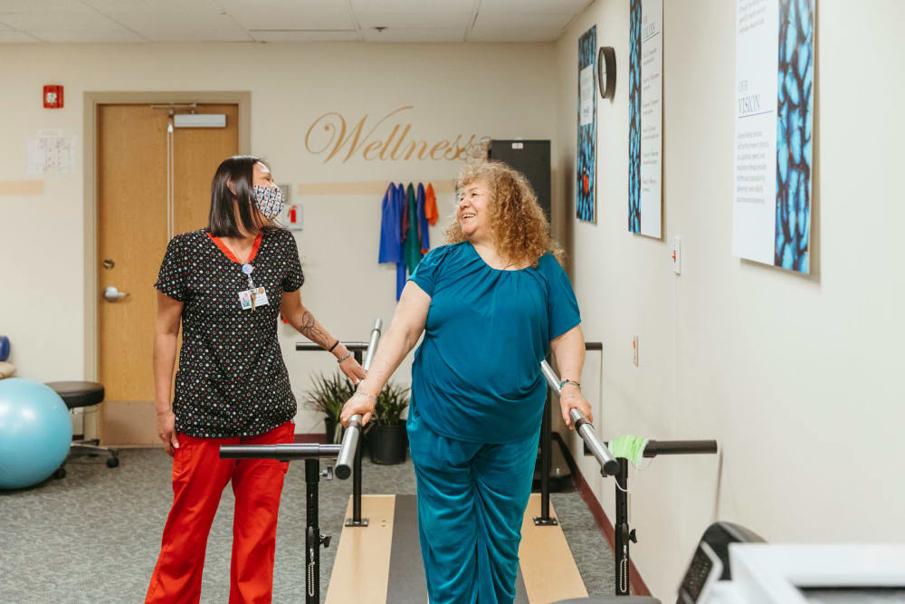 Certified nurse assisting a resident with some physical therapy at Cascade Park Adult Day Health in Tacoma, Washington