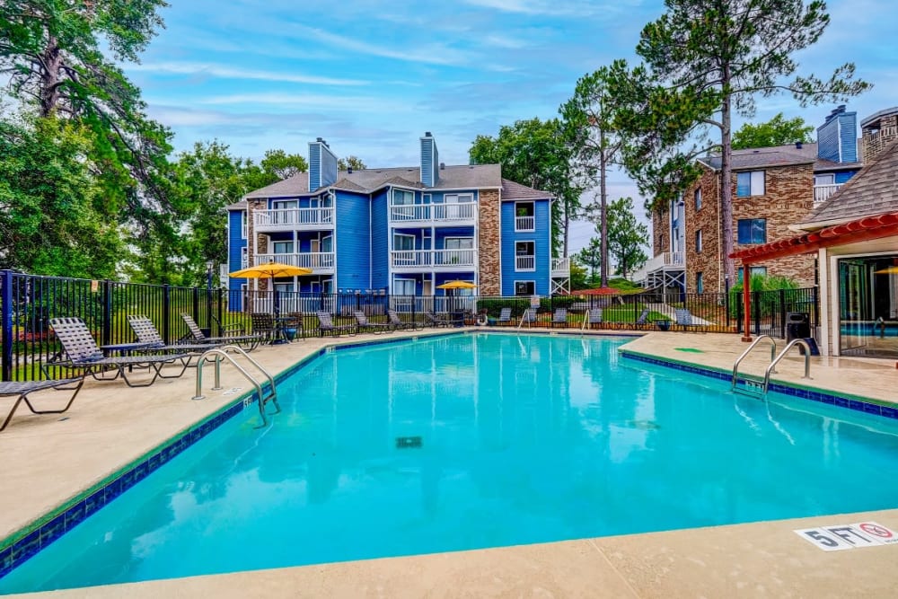Swimming pool with lounge chairs on the deck at Gable Hill Apartment Homes in Columbia, South Carolina