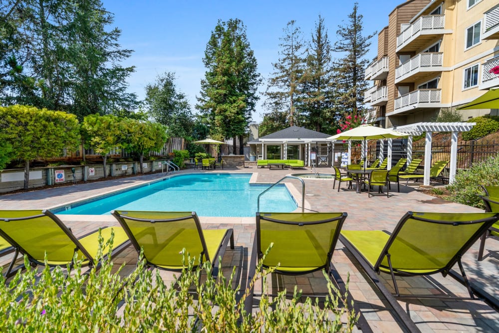 Resort-style pool and lounge chairs at Quail Hill Apartment Homes in Castro Valley, California