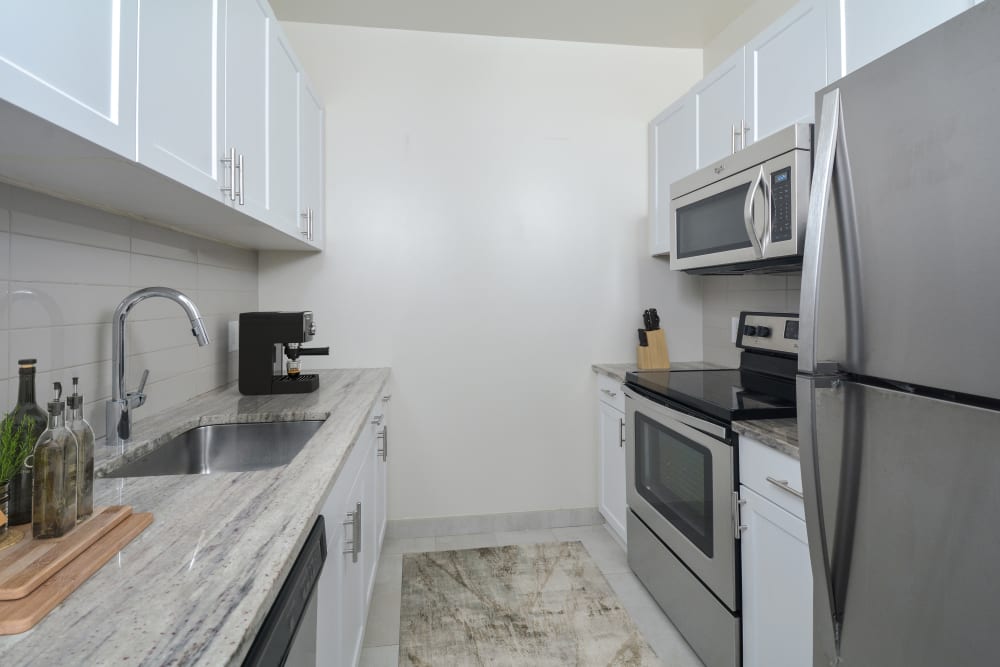 Newly renovated kitchen with stainless-steel appliances and white cabinetry at The Brunswick in New Brunswick, New Jersey