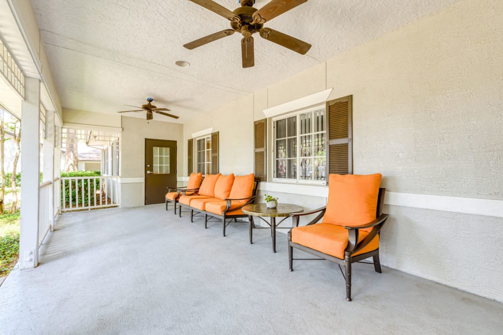 Outdoor patio with chairs and a fan at Pacifica Senior Living Belleair in Clearwater, Florida