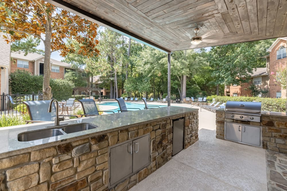 Grill station and pergola next to pool at Marquis at Kingwood in Kingwood, Texas