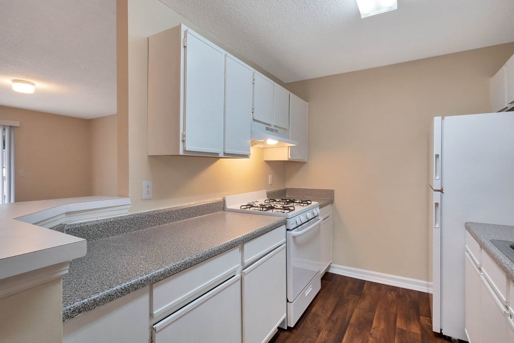 Kitchen with white cabinets at The Cove at Cloud Springs Apartment Homes in Fort Oglethorpe, Georgia
