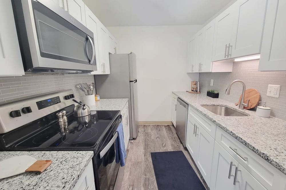 Kitchen with white cabinets, granite countertops, and stainless steel appliances